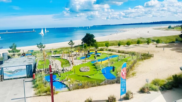 Ein Küstenresort mit Sandstrand, einer kleinen Poolanlage und Meerblick.