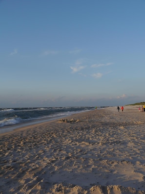 A beach with footprints and sand dunes.