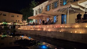A riverside terrace with stone steps, outdoor seating, and candles. - Light-flooded 90 sqm maisonette with balcony - suburb of the wine metropolis of Würzburg (Rottendorf)