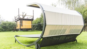 A hammock with a canopy, set up on a grassy lawn with a wooden structure in the background. - Apartment Casa Casimir with Elbe view balcony & large garden (for soccer/volleyball) (Dresden)