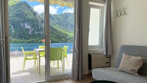 A room with a sliding glass door leading to an outdoor area with chairs and a table.