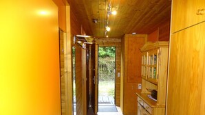 A wooden interior with a tiled floor, a wooden door, and a cabinet with glass doors. - Ideal nature: sunny home between a swimming lake, forest & the Altmühl River (Bayern)