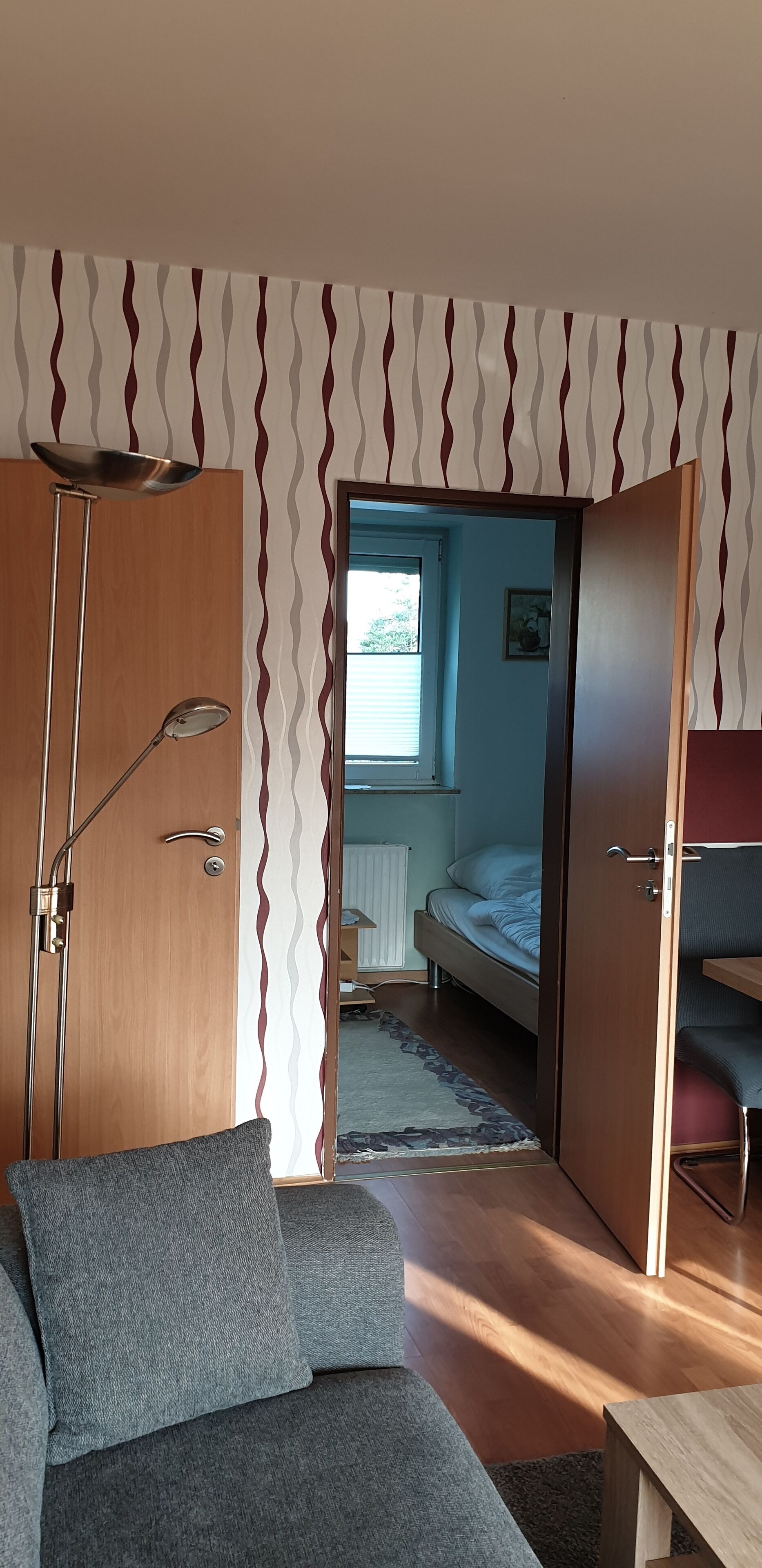 Une pièce de taille modeste comprenant un canapé, un lit, un bureau et une armoire.