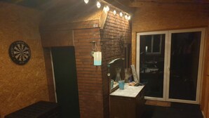 A room with a dartboard, a brick wall, a mirror, a window, and a door. - To get my head clear! Cozy cottage in Ditzum, large garden, dogs ok! (Ditzum)