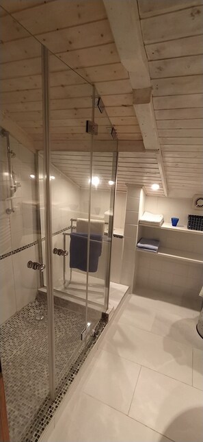 Een douche, een haardroger, handdoeken, toiletpapier