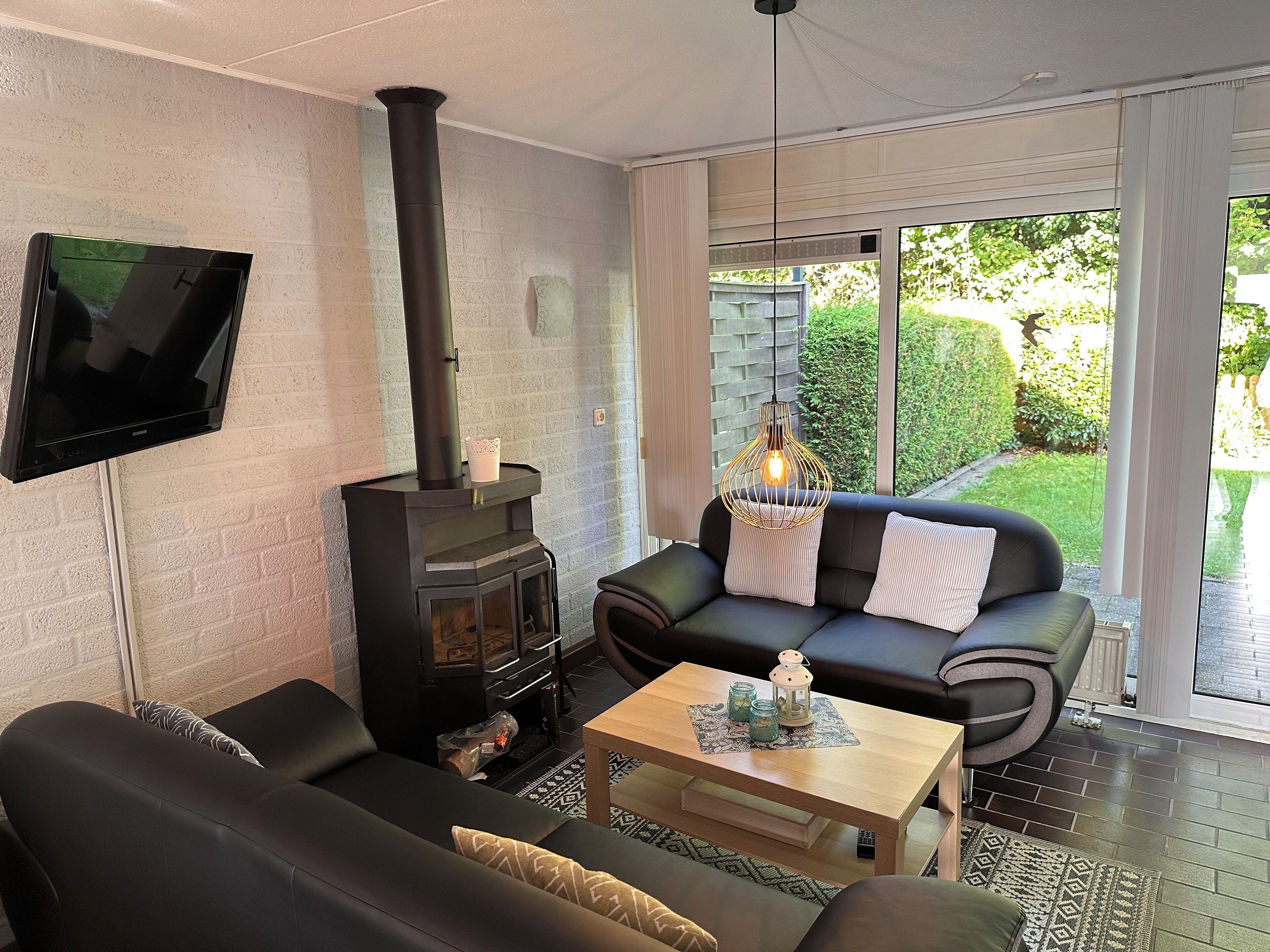 Wohnzimmer mit Kamin und Gartenblick