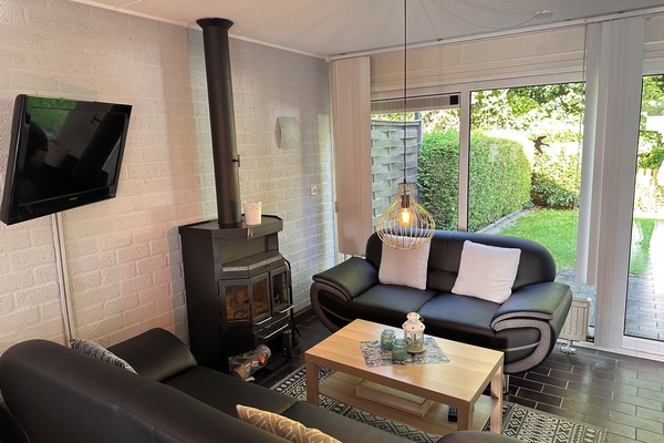 Wohnzimmer mit Kamin und Gartenblick