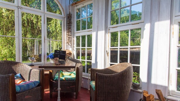 A sunroom with wicker furniture, a table, and a sign indicating a price of $39.