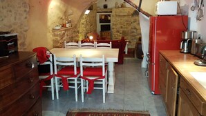 Une cuisine de taille réduite comprenant une table à manger, des chaises et un réfrigérateur.