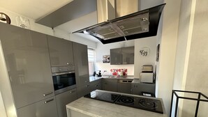 Une cuisine moderne équipée d’appareils électroménagers en acier inoxydable, d’un four encastré et d’une cuisinière à gaz.