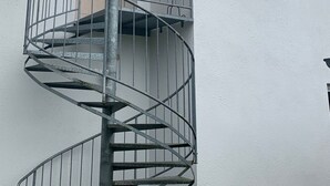 A white building with a red-tiled roof, a spiral staircase, and a small window. - Vacation, rest and relaxation in a relaxing natural (Rappin OT Helle)