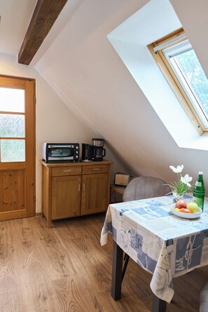 A kitchen with a skylight, wooden cabinets, a microwave, a toaster, and a table with a fruit bowl and a bottle. - Peace and relaxation in a restful natural setting (Rappin OT Helle)