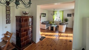 Un salon avec un plancher en bois, une cheminée, un canapé et une table basse.