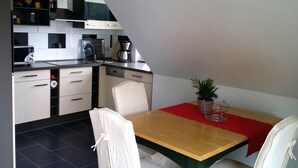 Eine moderne Küche mit weißen Schränken, einem Holztisch und einer roten Tischläufer.