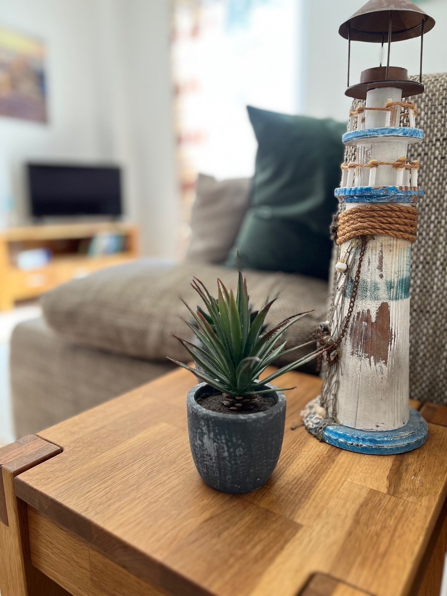 A wooden table with a potted plant and a rustic lantern.