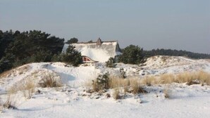 A snow-covered landscape with a small building on a hill. - 5min beach & forest, sunny, single storey (Prerow)