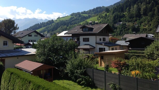 A rural village with traditional houses, surrounded by lush green hills and mountains. - Free mobility with public transport! (Zell am see)
