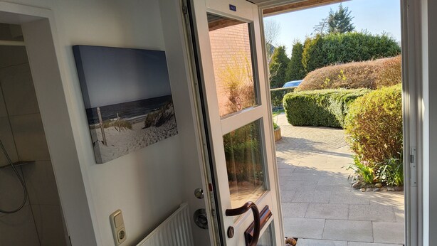 A door with a view of a beach, a welcome mat, and a doormat. - Renovated 2-room apartment, bright and friendly, dogs are welcome (Schönberg)