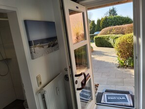 Una puerta con vista a la playa, felpudo y tapete.
