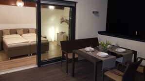 Une chambre moderne avec un grand lit et une porte-fenêtre coulissante donnant sur un balcon.