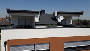 Un bâtiment moderne doté d’un toit plat, de grandes fenêtres et d’une antenne parabolique.