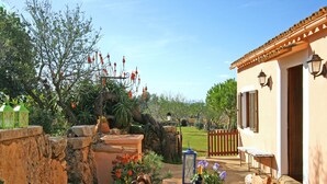 Un espace de restauration en plein air au charme rustique, avec des murs en pierre, des meubles en bois et une vue sur la campagne.