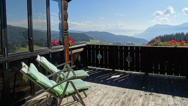 Um deck de madeira com vista para montanhas e um céu limpo.