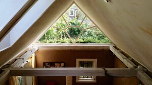 A room with a sloped ceiling and a skylight. - LÜNEBURG: Idyllic, bright garden house in the center of a historic half-timbered town (Lüneburg)