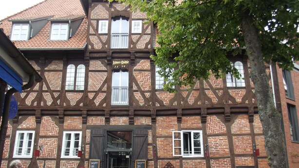 A traditional half-timbered building with a brick facade and timber framing. - LÜNEBURG: Idyllic, bright garden house in the center of a historic half-timbered town (Lüneburg)
