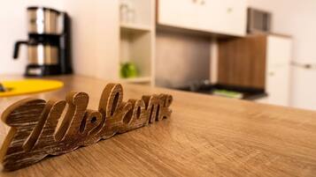 Un letrero de madera que dice 'Welcome' sobre una mesa de madera en una cocina.