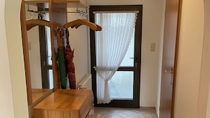 Ein Flur mit einem Holzboden, einem Spiegel und einer Tür zu einem Zimmer.