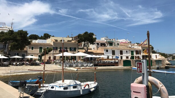 A marina with boats docked, a beach with umbrellas, and buildings with a supermarket sign. - House by the sea, private pool, sea view, roof terrace, air conditioning, WLAN, sep. Studio (Cala Serena)