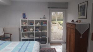 A bedroom with a bed, a bookshelf, a radiator, a window, and a door leading outside. - High-quality-modern, approx 65sqm, gr. Garden, exclusive equipment, wirkl. gr. bathroom (Lüneburg)