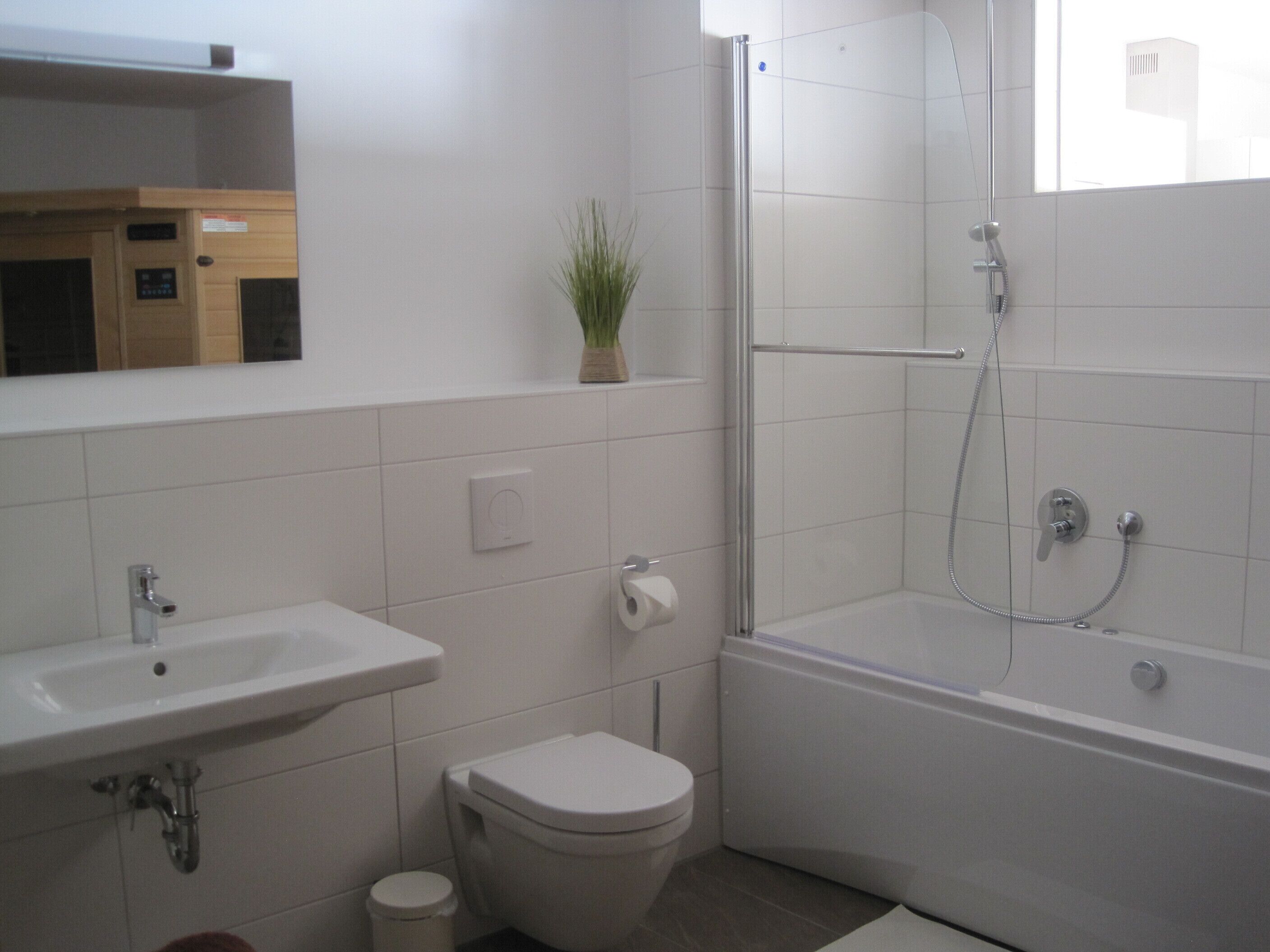 Une salle de bain avec un lavabo, des toilettes et une douche.