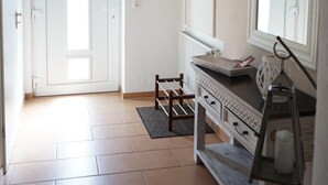 A bright, well-lit room with a white door, a large mirror, and a wooden cabinet.