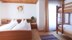 A bedroom with a bunk bed, a bedside table with a plant, a framed picture on the wall, and a striped rug on the floor. - 4 to 12 people, ski vacation, hiking vacation, cultural vacation, quiet dreamlike location (Schlitters)