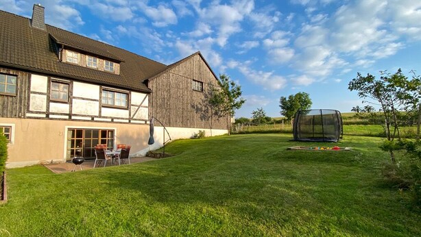 A large house with a well-maintained lawn and a barbecue area. - Cozy vacation apartment in the countryside - ideal for switching off & relaxing (Niederbobritzsch)