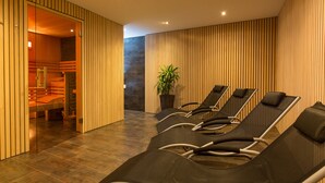 Un espace de détente avec des fauteuils inclinables, un mur en bois et une plante en pot.
