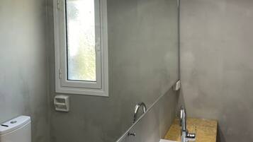 A compact bathroom with a toilet, sink, and window.