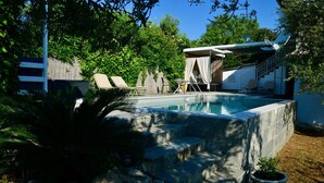 A swimming pool with steps leading into it, surrounded by a stone wall and potted plants. - Top holiday home private pool by the sea with private garden for single use (Koroni/Harakopio)