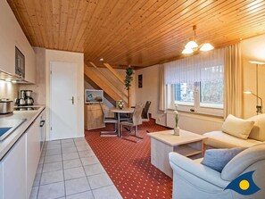 Et hyggeligt værelse med tekøkken, spiseplads og opholdsstue.
