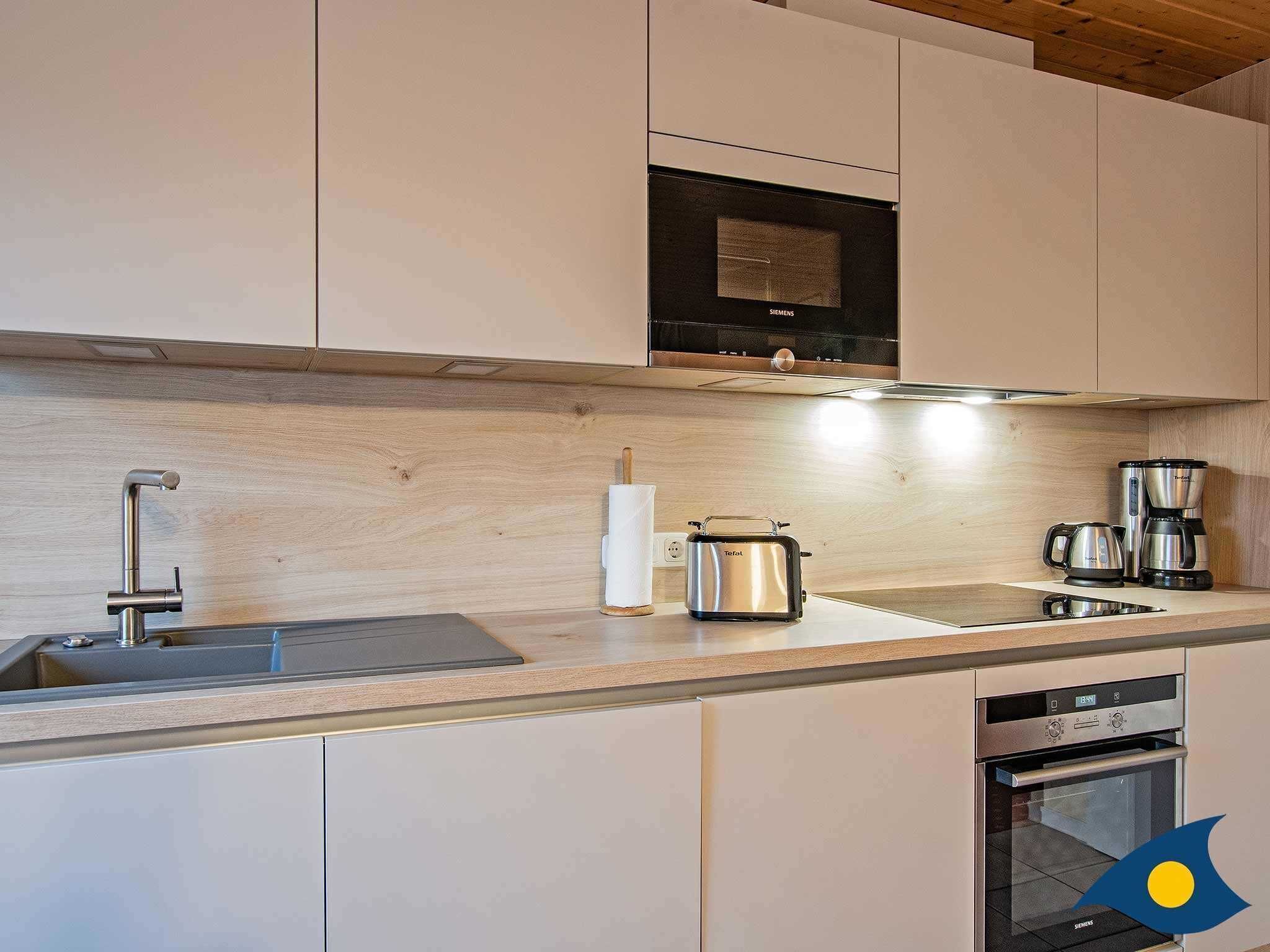 A modern kitchen with a stainless steel toaster, coffee maker, and oven.