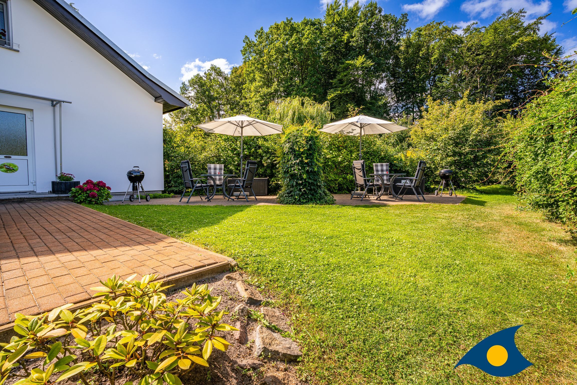 A patio area with outdoor furniture, a barbecue grill, and a well-maintained lawn.