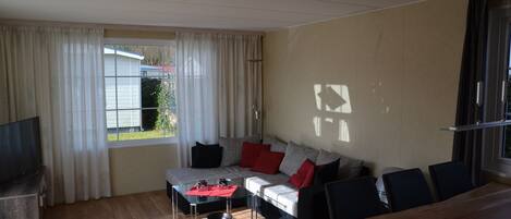 Una sala de estar con sofá, mesa de centro y mueble para la televisión.