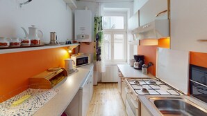 Uma cozinha compacta com fogão a gás, micro-ondas e forno pequeno.