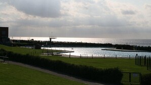 Un parc au bord de l’eau, doté d’une plateforme d’observation, de sentiers et d’une étendue d’eau.