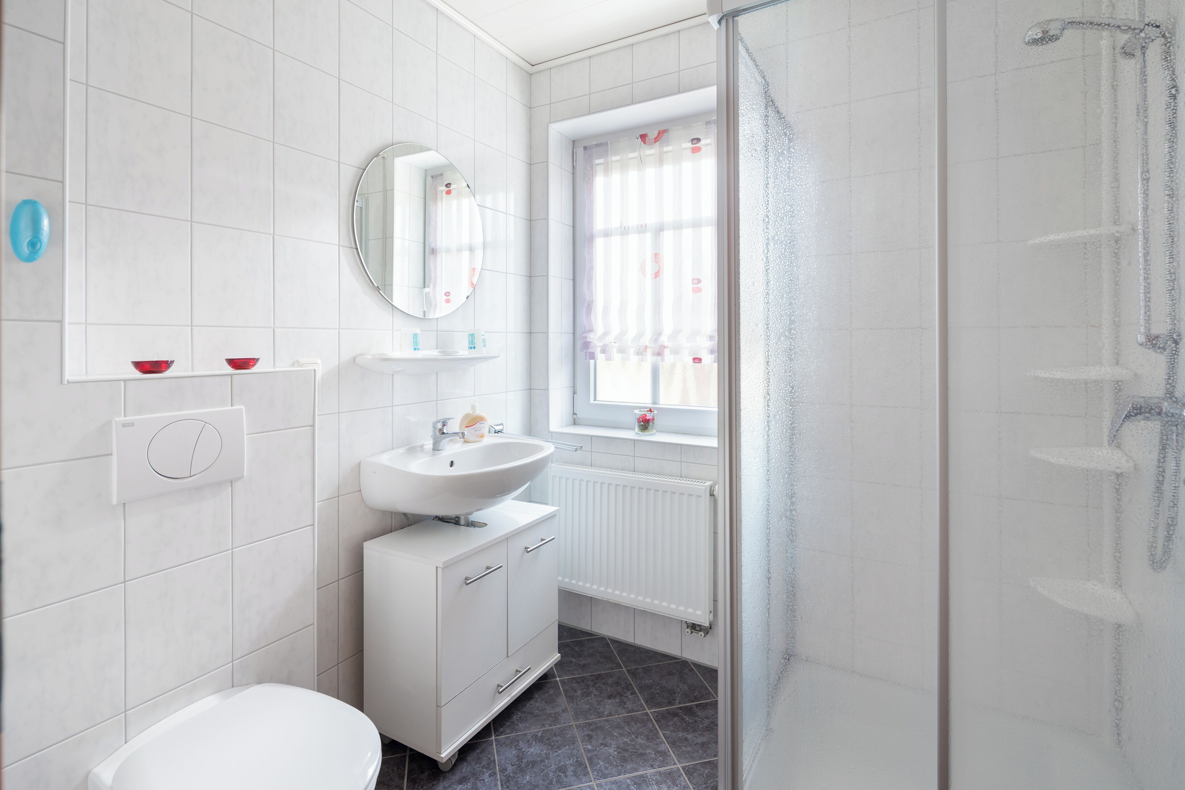 Un baño moderno con inodoro, lavabo y ducha.