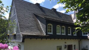 A traditional building with a steeply pitched roof, multiple windows, and a small door. - Panorama-FeWo**** BEI WINTERBERG, 2 -10 pers., box-spring beds, WIFI / WLAN  (Schmallenberg)