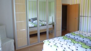 A bedroom with a bed, a wardrobe, and a mirror. - **** late harvest apartment (Leiwen)