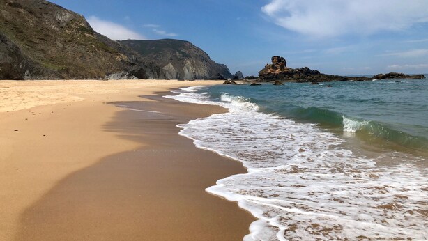 A beach with clear waters, a sandy shore, and rocky formations in the background. - new holiday house with pool and exclusive furniture (Sagres)